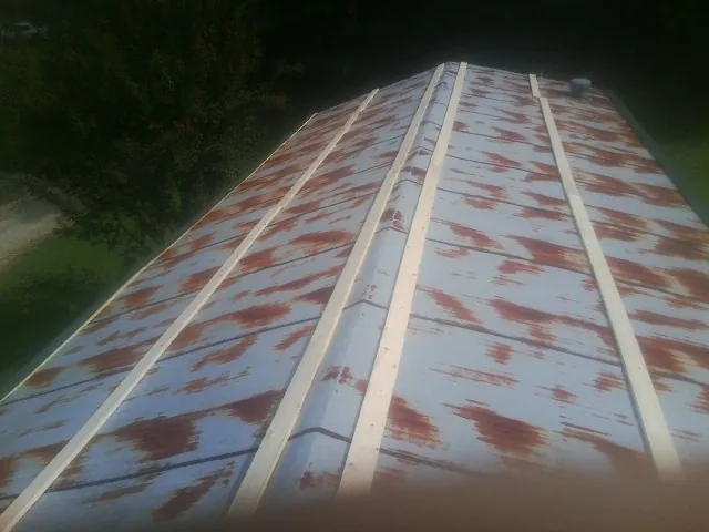 Rusted metal roof panels with new wood purlins before replacement — Storm Damage Roof Repair in Ainsworth by Roofing Brothers