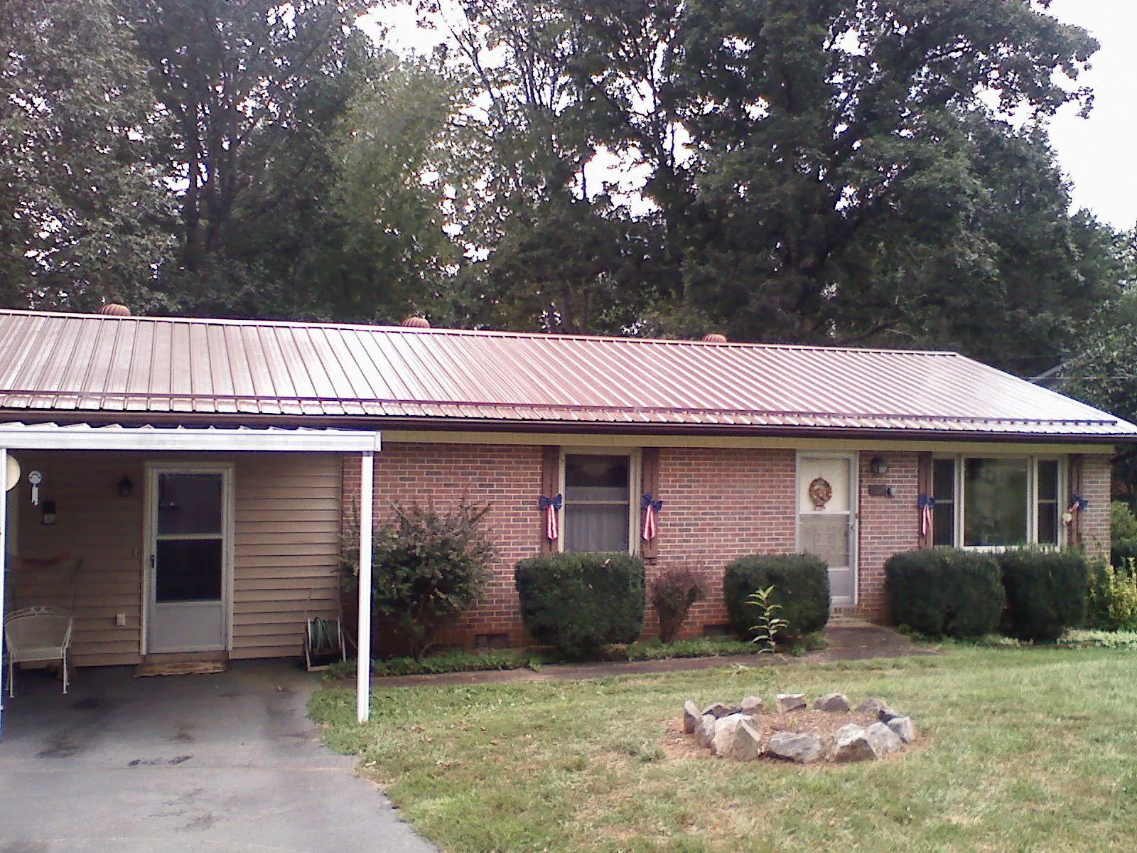 Bronze metal roof and carport on a brick ranch home — Roof Repair work by our crew in Ainsworth