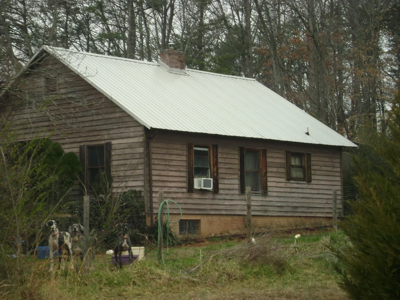 White metal roof on an old wood sided farmhouse, from a Metal Roof Installation job in Ainsworth